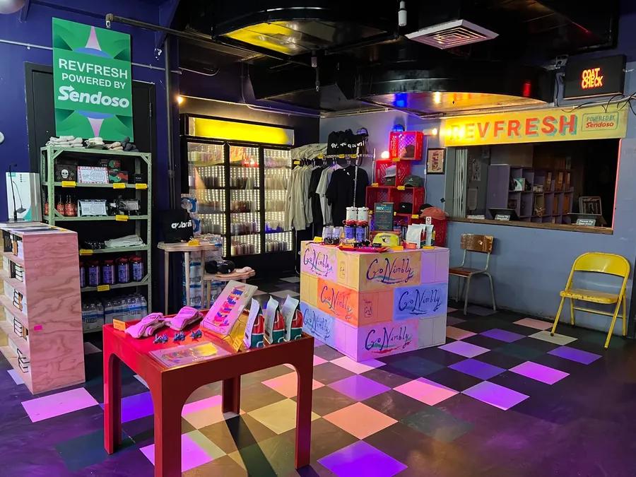 The Sendoso REVFRESH shop activation, counters stacked with merch over a checkerboard floor